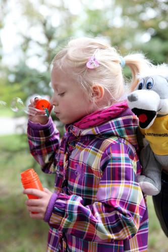 a little girl holding a stuffed animal and a toy at Sonnenhotel Hoher Hahn in Schwarzenberg