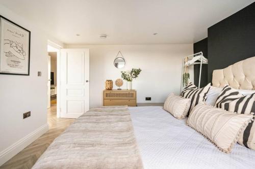 1 dormitorio con 1 cama grande con almohadas en The Snug Penthouse, en Sittingbourne