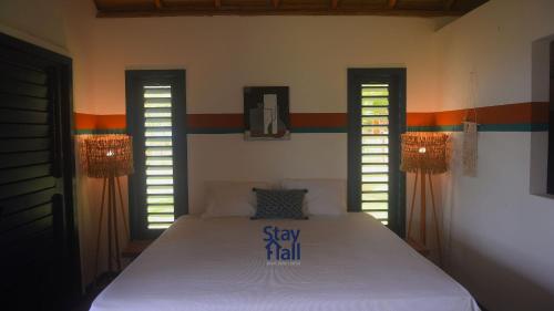 een slaapkamer met een bed met 2 ramen en een bordje erop bij Casa Beira Mar-Praia Pontal de Maceio-Fortin-7 Suites e Piscina Privativa-084 in Fortim