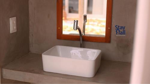 um lavatório branco numa casa de banho com uma janela em Retiro sereno c Piscina-Casa Manga-4 quartos-085M em Fortim