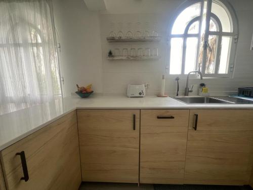 a kitchen with wooden cabinets and a sink and a window at Tavira Garden Oasis in Tavira