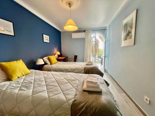 a bedroom with two beds and a window at Tavira Garden Oasis in Tavira