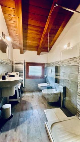 a bathroom with two sinks and a tub and a toilet at La Sellerie in Nus