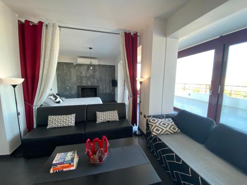 a living room with a bed and a couch at Luxury view apartment 10min from Athens airport in Koropíon