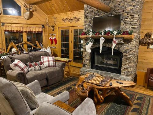 a living room with a stone fireplace with a chess board at Beautiful 6 bdr cabin with hot tub in the Smokies! in Pigeon Forge