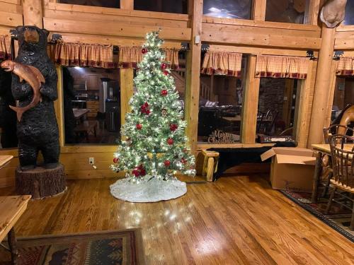 a christmas tree in the middle of a room at Beautiful 6 bdr cabin with hot tub in the Smokies! in Pigeon Forge