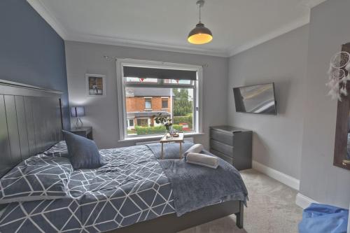 um quarto com uma cama e uma janela em Modern home w private driveway and garden near Belfast City Centre em Belfast