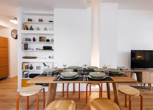 une salle à manger avec une table avec des assiettes et des verres à vin dans l'établissement 3 Pièces avec balcon, 10 minutes PARIS, à Alfortville
