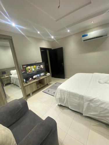 شقة مفروشة في جدة: غرفة نوم بسرير واريكة وتلفزيون