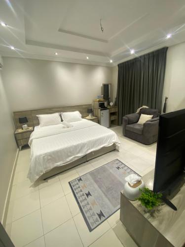 a bedroom with a bed and a couch and a television at شقة مفروشة in Jeddah