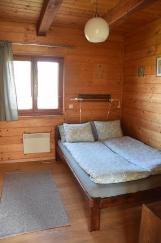 ein Schlafzimmer mit einem Bett in einer Holzhütte in der Unterkunft Málnás Vendégház-Raspberry Guesthouse in Nagymaros