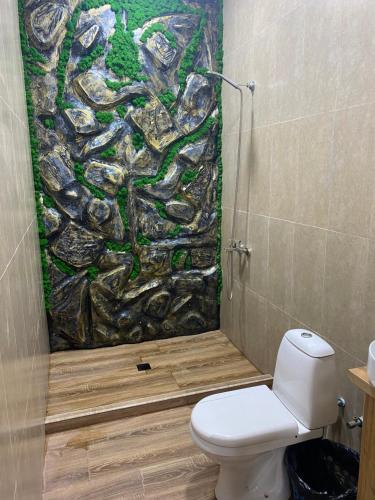 a bathroom with a toilet and a painting on the wall at For the best in Sevan