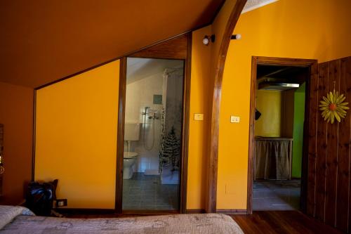 a bedroom with yellow walls and a sliding glass door at B&B Pian Savin in Giaveno