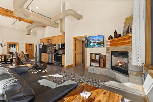 a living room with a couch and a fireplace at Spacious Dtwn Estes Park Loft Condo 4 Mi to RMNP in Estes Park