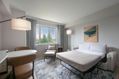 a hotel room with a bed and a table at The Westin Sacramento Riverfront Hotel & Spa in Sacramento