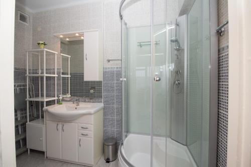 bagno con doccia in vetro e lavandino di Beach Apartman a Zamárdi