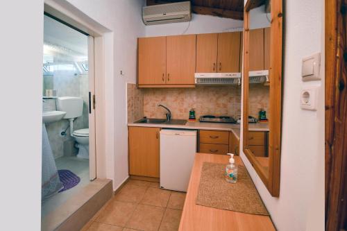 a small kitchen with wooden cabinets and a sink at Nikos House in Myrtos