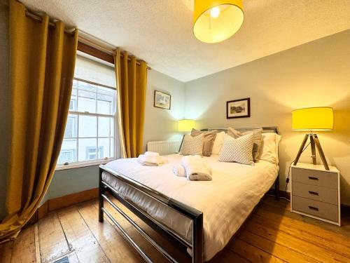 a bedroom with a large bed and a window at The Old Locksmith Cottage, Ulverston - Lake District in Ulverston