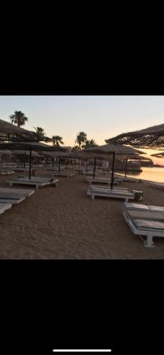 a group of picnic tables on a sandy beach at Al mashrabiya apartment 2 bed room in Hurghada