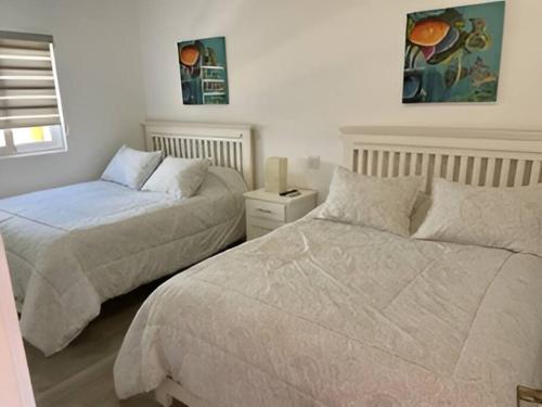 a bedroom with two beds and a window at 2C Stunning Top Floor Unit, Breathtaking Ocean Views in San Carlos