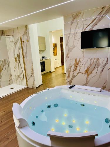 a bath tub in a room with a television and a bathroom at Suite169 Gold in Bari
