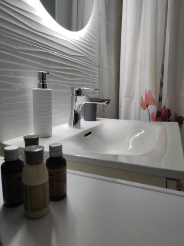 a bathroom with a white sink and a mirror at Stafétaház Apartmanok in Vác