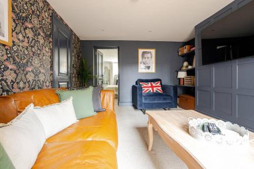 The Snug Den في Kent: غرفة معيشة مع أريكة وكرسي