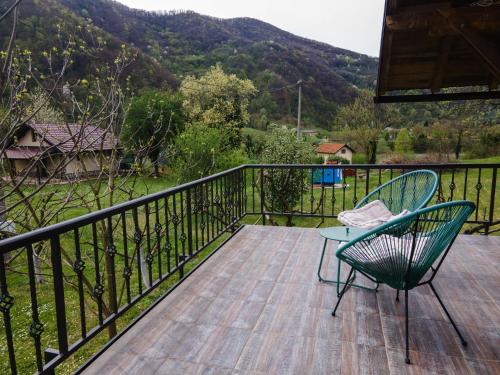 a balcony with a chair and a table and a mountain at Dedin Drinski Dom in Bajina Bašta