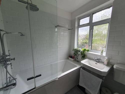 W łazience znajduje się wanna, umywalka i prysznic. w obiekcie Charming 3 Bed House Bromley London w mieście Bromley