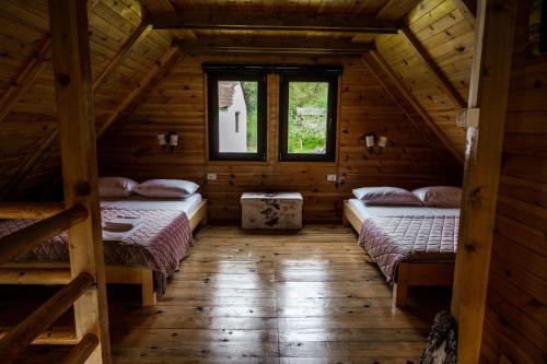 a bedroom with two beds in a log cabin at Dedin Drinski Dom in Bajina Bašta