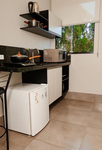 a kitchen with a white refrigerator and a counter at Vila Castelo Residencial no Centro de Foz in Foz do Iguaçu