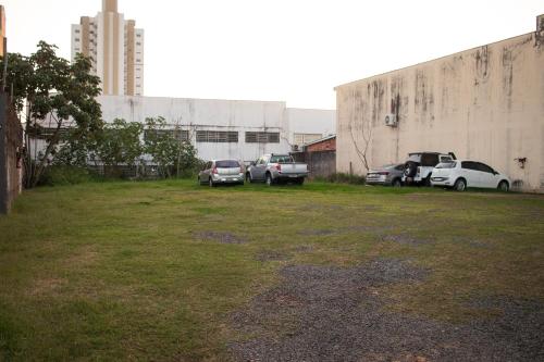 a parking lot with cars parked next to a building at Vila Castelo Residencial no Centro de Foz in Foz do Iguaçu