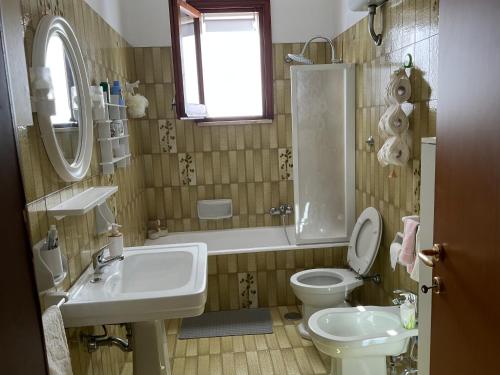 ein Badezimmer mit einem Waschbecken, einem WC und einer Badewanne in der Unterkunft “da nonna Lucia” in Lequile