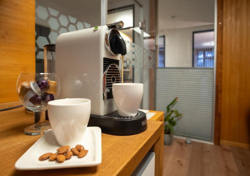 una cafetera sentada en un mostrador con dos tazas en Ferienwohnung Der Gerber en Hilden