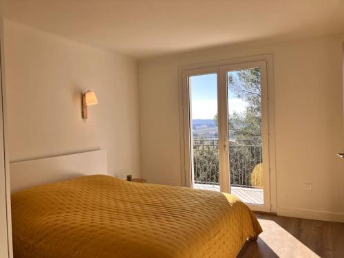 ein Schlafzimmer mit einem Bett und einem großen Fenster in der Unterkunft Villa Spacieuse dans le sud de la France in Piolenc