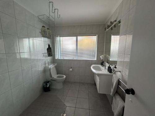 a white bathroom with a toilet and a sink at River Heights in Taupo