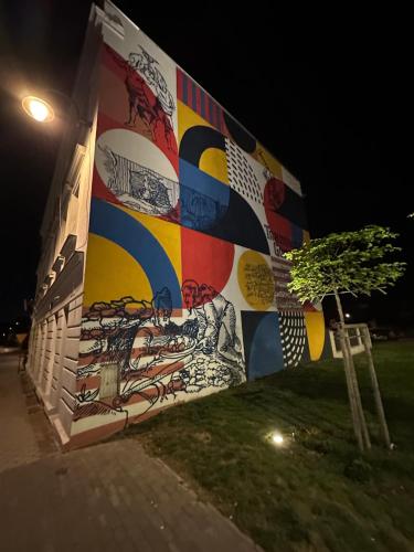 a wall with a painting on it at night at Apartament Opolska 5 in Tarnowskie Góry