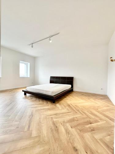 a bedroom with a bed and a wooden floor at Apartament Opolska 5 in Tarnowskie Góry