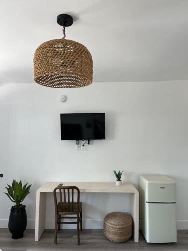 a room with a white desk with a chair and a television at Anaheim Maingate Inn in Anaheim