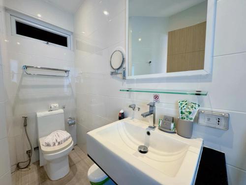 een witte badkamer met een wastafel en een toilet bij Cozy Studio Rawai Beach Phuket in Ban Saiyuan (1)