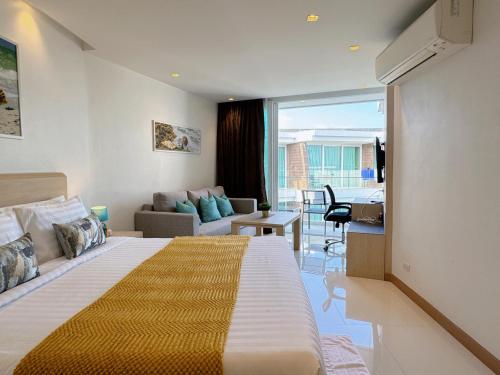 een hotelkamer met een bed en een woonkamer bij Cozy Studio Rawai Beach Phuket in Ban Saiyuan (1)