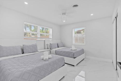 een witte kamer met een bed en een bank bij Pompano Gem, 1 mi to Beach & 12 Pickleball courts in Pompano Beach