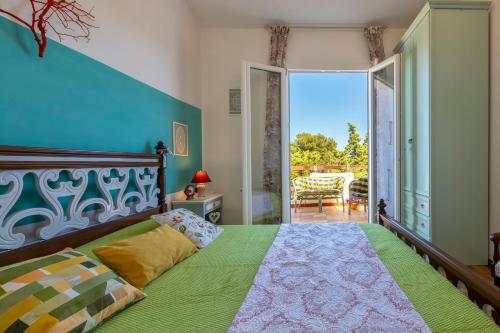 Schlafzimmer mit einem Bett mit grüner Tagesdecke in der Unterkunft La Conchiglia in Marina di Sorso
