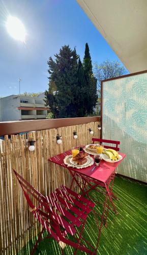 une table rouge avec des assiettes de nourriture sur une terrasse dans l'établissement T2 60m2, Centre Ville, Parking Gratuit, Terrasse, Proche Tram, à seulement 15mn des Plages, à Montpellier