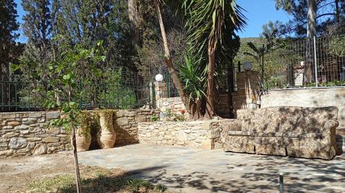 a stone bench sitting in a yard next to a stone wall at Entire cottage near the beach in Nimporio, Euboea in Nimporio