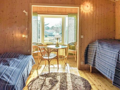 um quarto com duas camas e uma mesa e uma janela em Holiday home ELLÖS II em Ellös