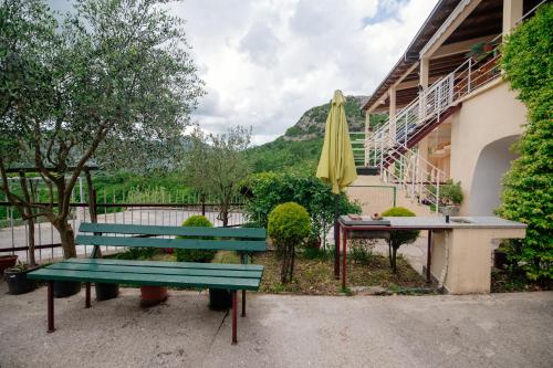 a green bench next to a table and an umbrella at Omni S Apartments in Bar