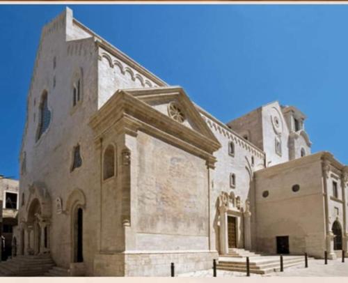 un grande edificio in pietra con una torre dell'orologio di Amasté in Puglia CASA VACANZA a Bisceglie