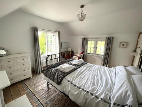 um quarto com uma cama, uma cómoda e uma janela em The Cottage, Marlow em Buckinghamshire