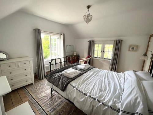 a bedroom with a bed and a dresser and window at The Cottage, Marlow in Buckinghamshire